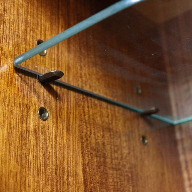 Close-up of vintage teak wood grain with a glass shelf bracket, showcasing mid-century British craftsmanship on G-PLAN.