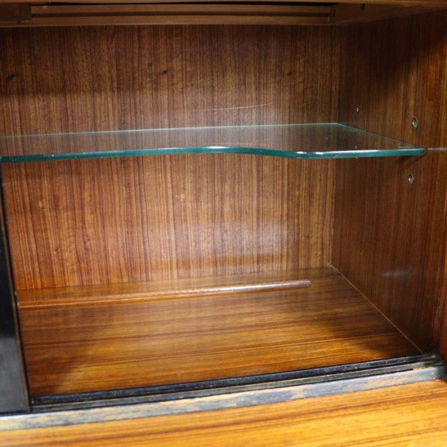 Vintage teak cabinet interior with rich wood grain and a glass shelf, mid-century British design.