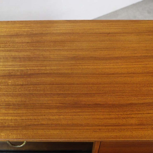 Close-up of vintage British mid-century teak highboard top showing smooth wood grain and warm honey tones.