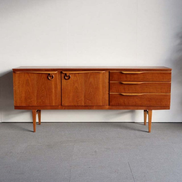 Mid-century British vintage teak sideboard by Beautility with smooth wood grain, two doors on left, three curved handle.