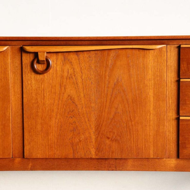 Vintage teak mid-century sideboard by Beautility with smooth wood grain and ring handle detail, British-Danish design.