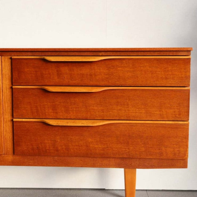 Vintage teak sideboard by Beautility with British mid-century design, smooth wood grain, tapered legs, and sleek drawer.