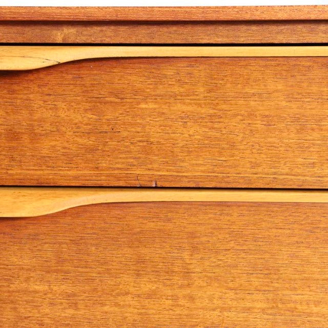 Close-up of vintage British mid-century teak sideboard by Beautility showing smooth wood grain and curved drawer edges.