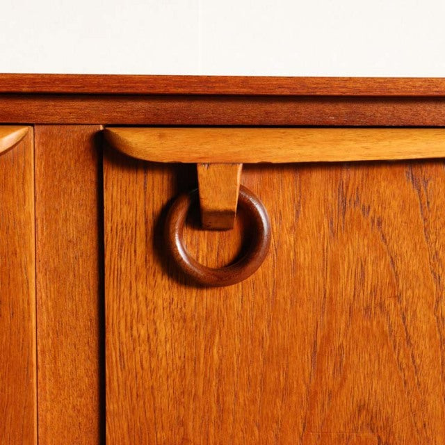 Mid-century British teak sideboard by Beautility with rich wood grain and distinctive circular handle detail.
