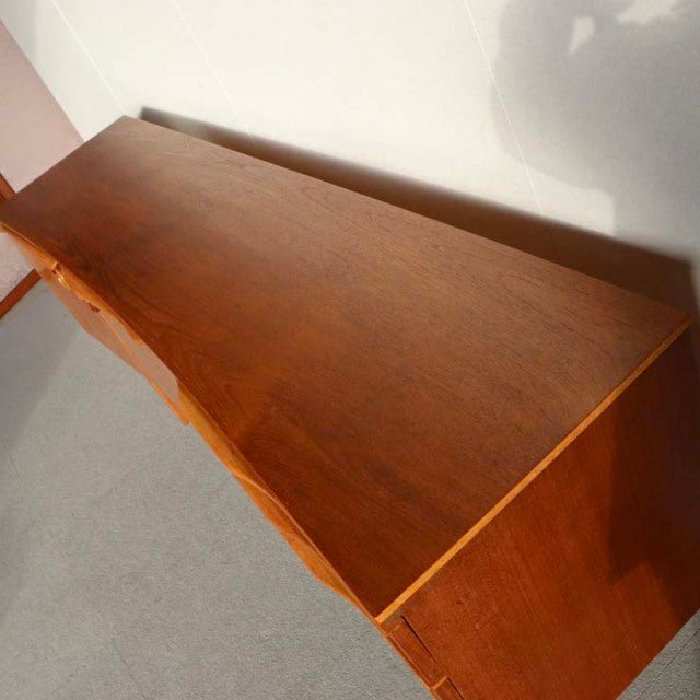 Vintage British mid-century teak sideboard by Beautility with smooth wood grain and clean lines, Denmark design influence.
