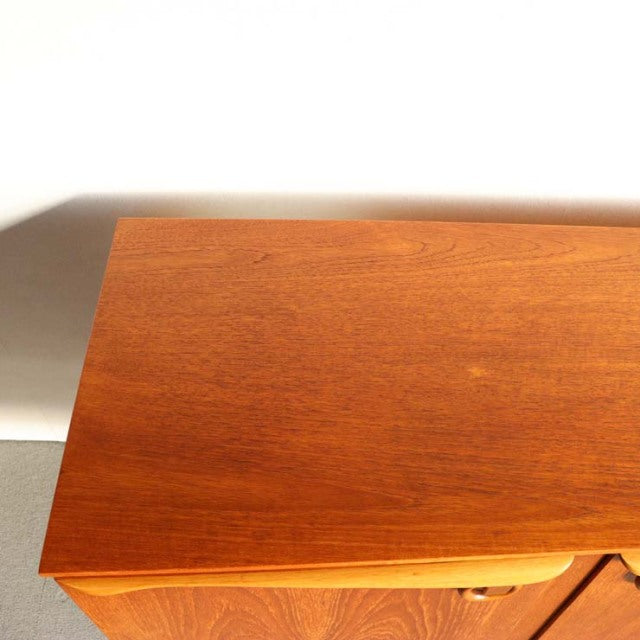 Vintage teak sideboard top with rich wood grain, smooth surface, and warm mid-century British-Danish design.
