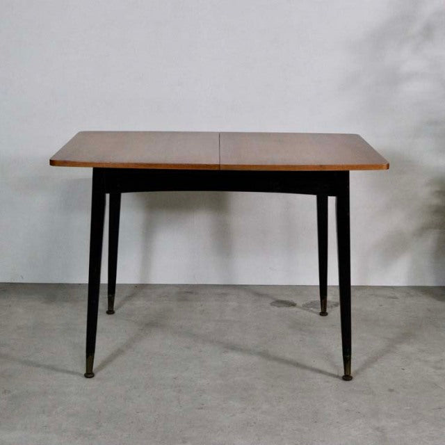 Vintage mid-century British teak dining table with rectangular top, slender tapered legs, and brass-capped feet.