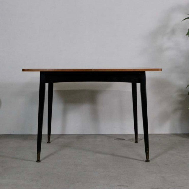 Vintage teak dining table with rectangular top, slim tapered black legs, mid-century British-Denmark design.
