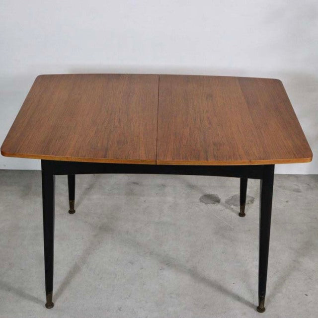 Vintage teak mid-century British dining table with sleek rectangular top and tapered black legs from Denmark.