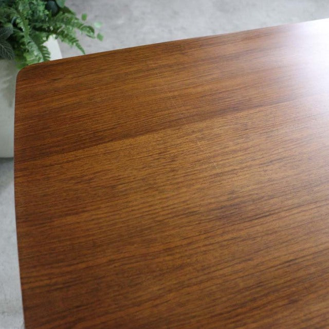 Vintage mid-century British teak dining table with smooth wood grain and rounded corner details.