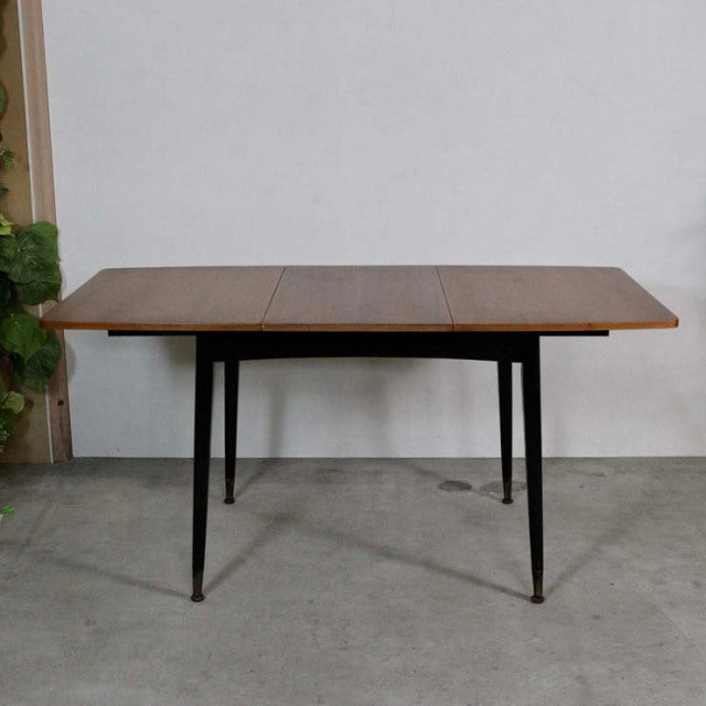 Vintage teak British mid-century dining table with grain wood top and tapered black legs.