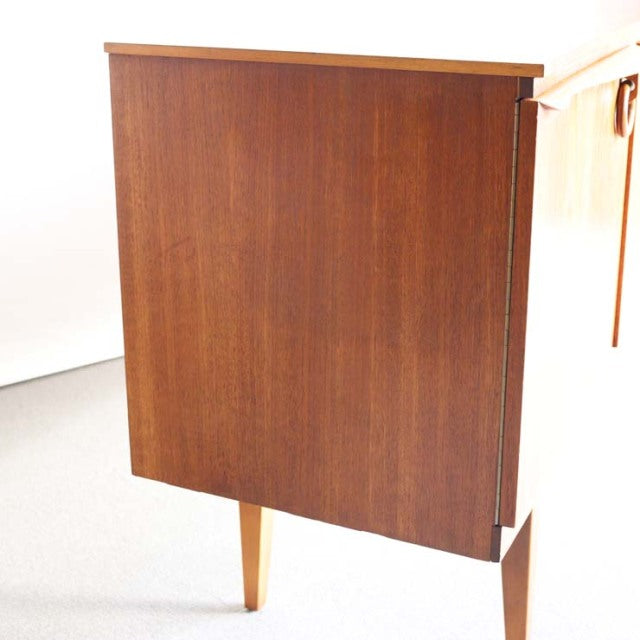 Vintage teak sideboard by Beautility, British mid-century design with clean lines and tapered legs, rich wood grain visible.