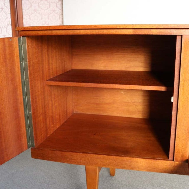 Vintage teak sideboard by Beautility with mid-century British-Denmark design, showcasing smooth wood grain and tapered legs.
