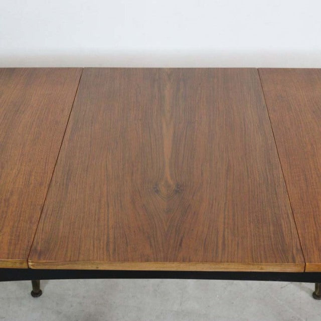 Vintage mid-century British teak dining table with rich wood grain and slender tapered legs.