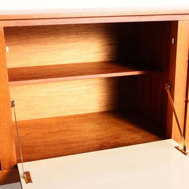 Vintage teak sideboard by Beautility showcasing rich wood grain, mid-century British design with sleek shelving and.