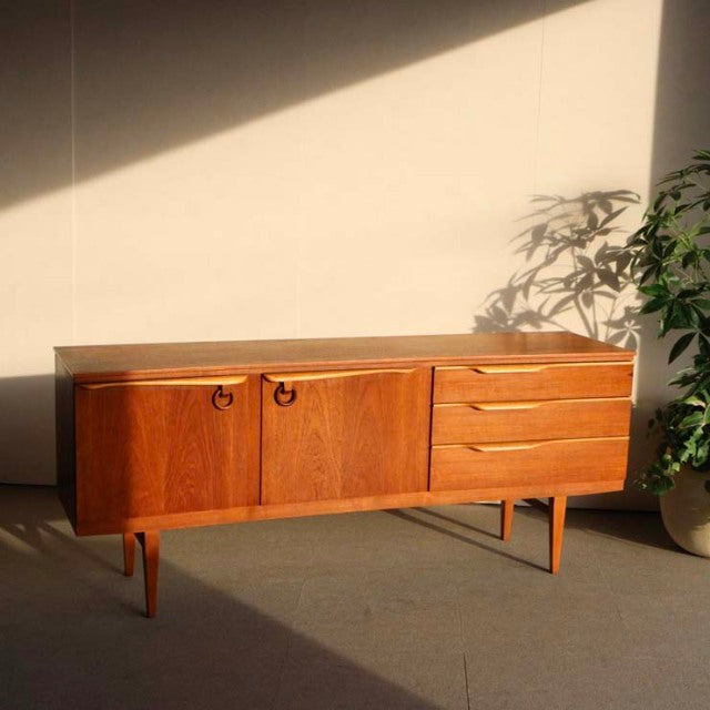 Mid-century British teak sideboard by Beautility with rich wood grain, rounded handles, tapered legs, and a warm vintage.