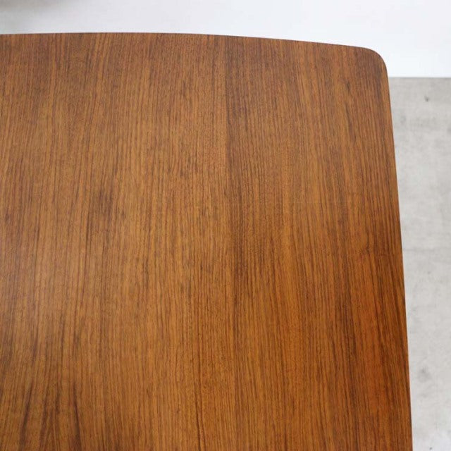 Corner view of vintage British mid-century teak dining table top showing rich wood grain and rounded edges.
