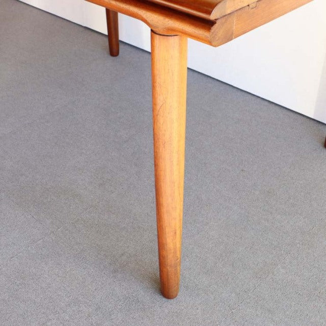 Mid-century British vintage teak dining table leg with smooth tapered design and visible wood grain.