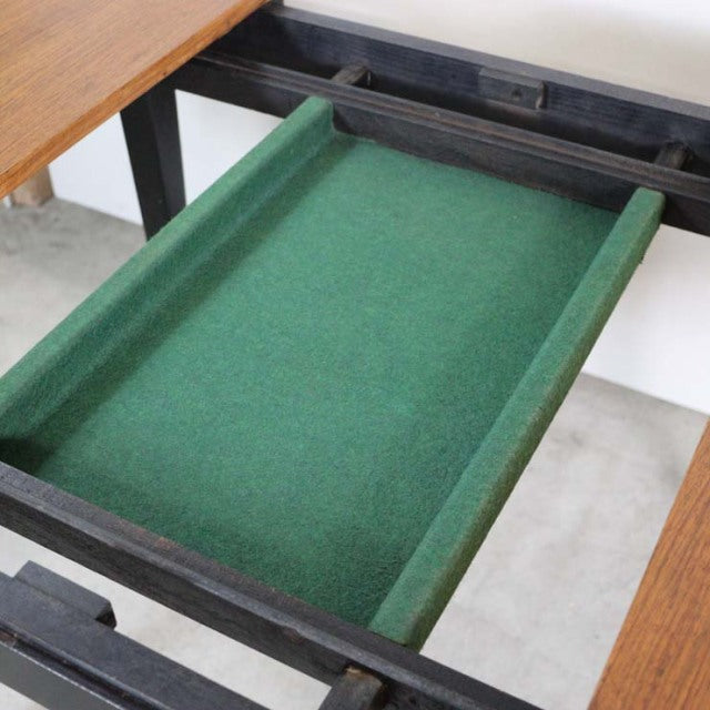 Vintage British mid-century teak dining table showing a green felt-lined drawer with black wooden frame and smooth wood.