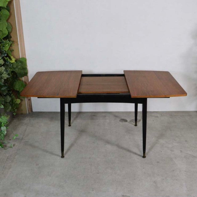 Vintage mid-century teak dining table from Denmark with rectangular top and slender black tapered legs.