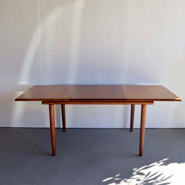 Mid-century British vintage teak dining table by WhiteANDnewton, rectangular with tapered legs and visible wood grain.