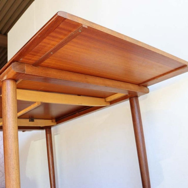 Vintage British mid-century teak dining table by WhiteANDnewton with sleek rectangular top and slender round legs.