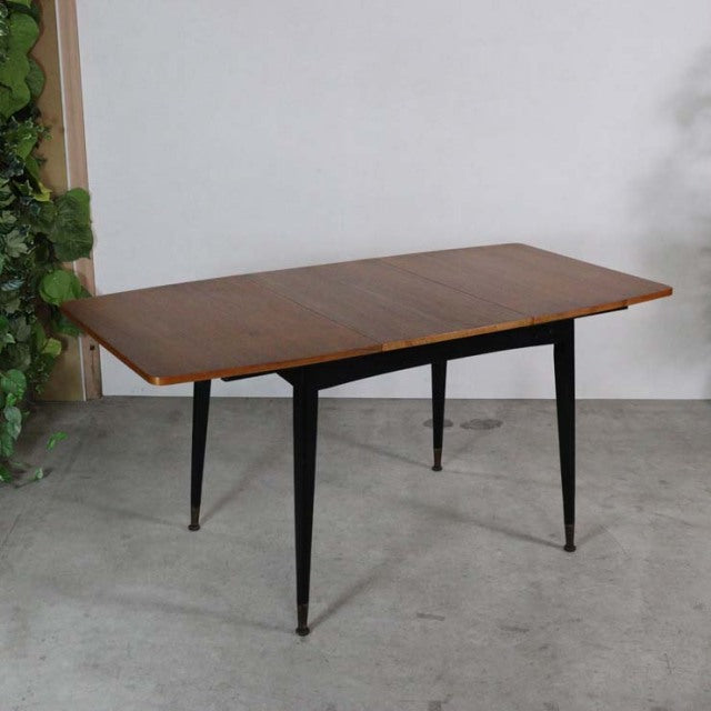 Vintage teak rectangular dining table with mid-century British design, tapered black legs, smooth wood grain surface,.