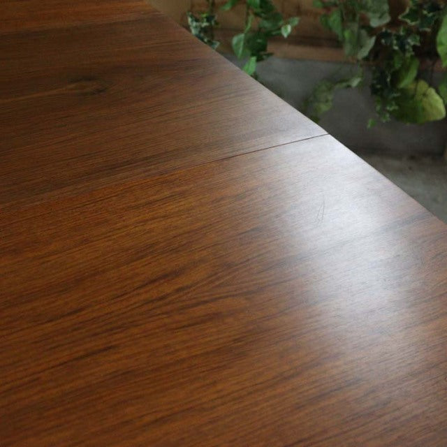 Vintage mid-century British teak dining table with smooth wood grain and rectangular top.