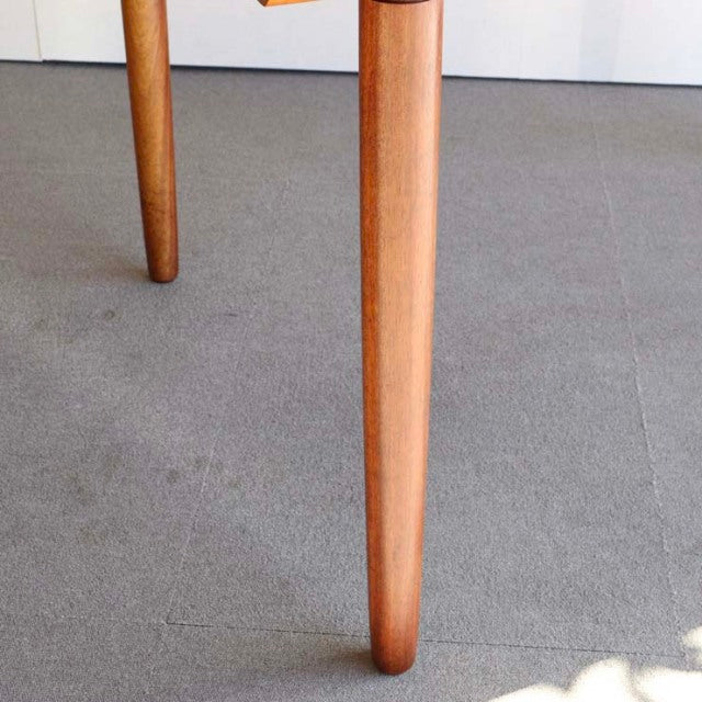 Mid-century British teak dining table leg with tapered design and smooth wood grain finish.