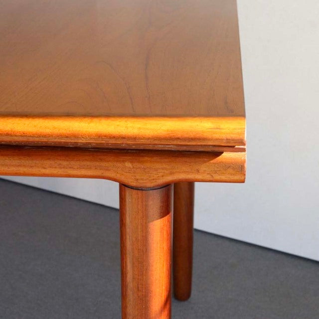 Mid-century British teak dining table corner with smooth grain and rounded leg detail by WhiteANDnewton.