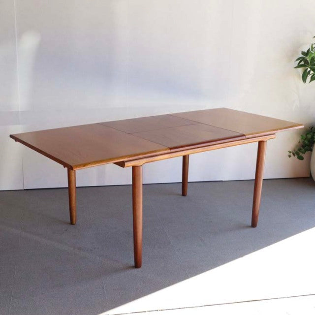 Vintage British mid-century dining table in teak with rectangular top and tapered round legs by WhiteANDnewton.