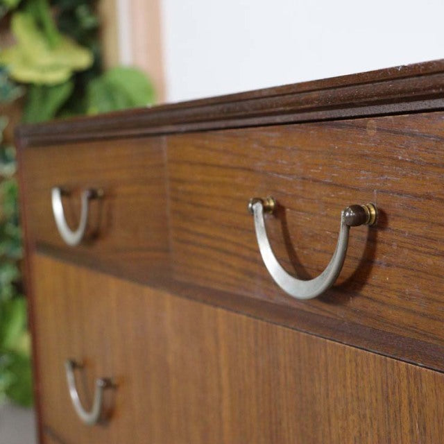Vintage British mid-century teak chest by Meredew with rich wood grain and curved metal handles.
