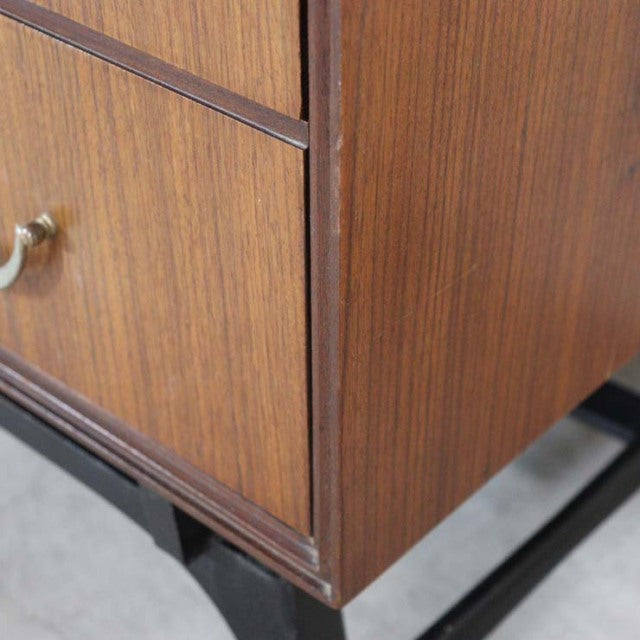 Vintage teak British mid-century chest corner showing fine wood grain and smooth edges on slender legs.