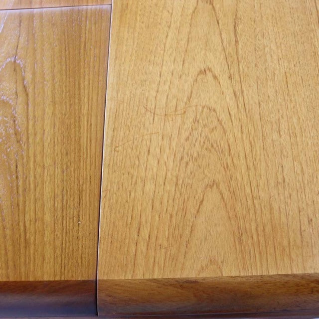 Close-up of vintage British mid-century teak dining table showcasing smooth wood grain and rounded edges.