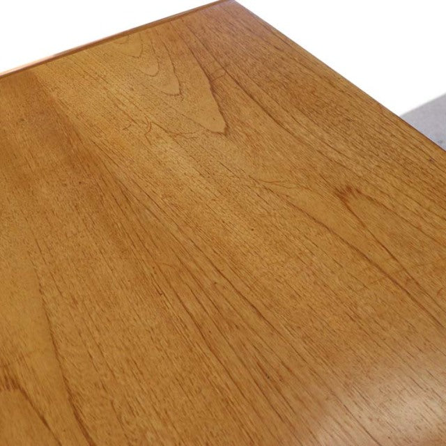 Vintage teak dining table corner with visible wood grain and smooth mid-century British craftsmanship.