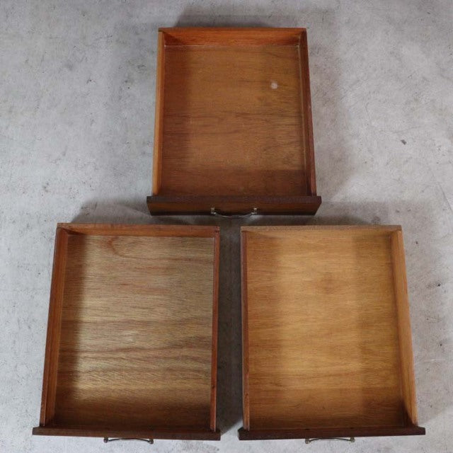 Set of three vintage teak drawers with smooth wood grain, brass handles, and mid-century British design from Meredew.