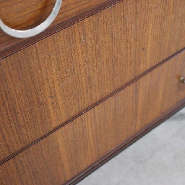 Close-up of vintage teak wood grain on British mid-century Meredew chest drawer front with smooth finish.