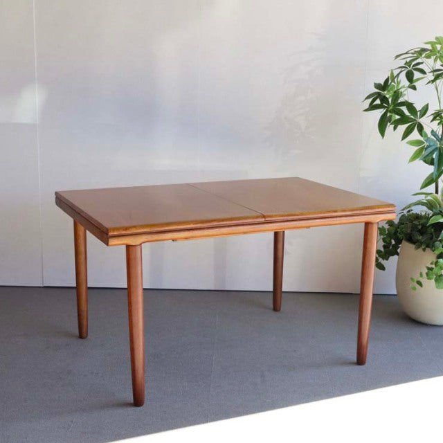 Mid-century British vintage teak dining table by WhiteANDnewton with rectangular top and tapered legs in natural wood grain.
