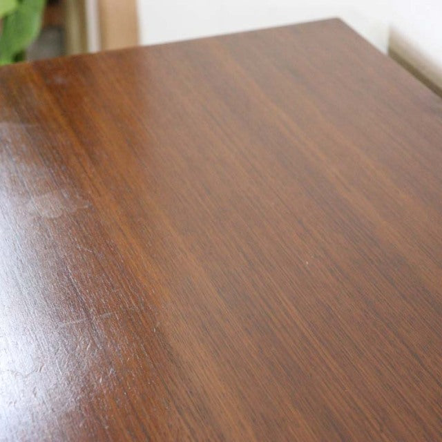 Close-up of vintage British mid-century teak chest surface showing rich wood grain and smooth finish.