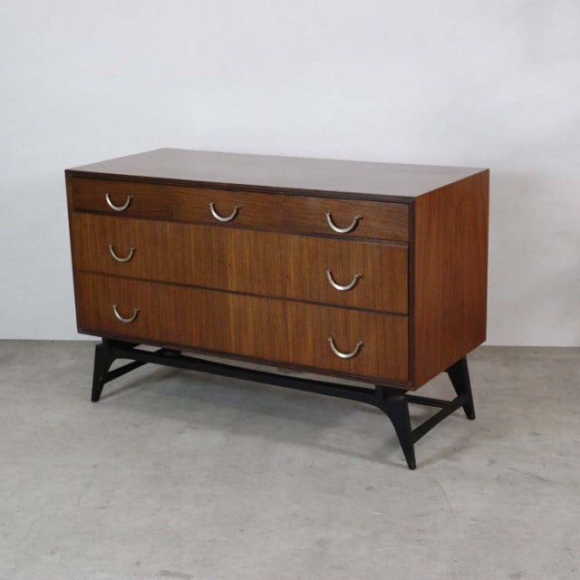Mid-century British vintage teak chest with three drawers, curved metal handles, and black angled legs from Meredew.