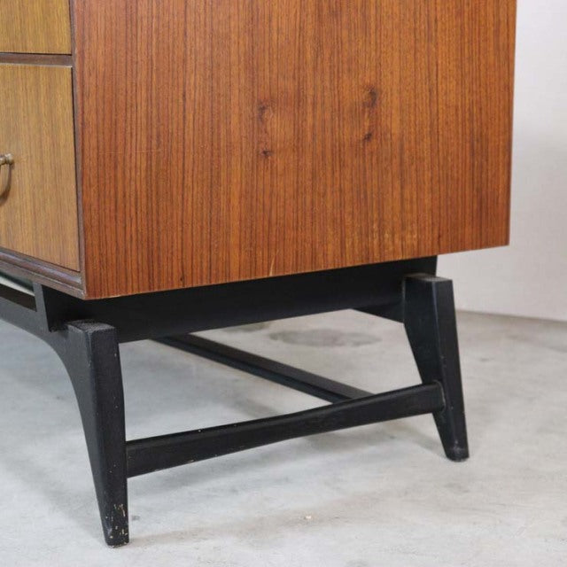 Vintage mid-century teak chest with warm wood grain, black angled legs, and sturdy cross supports, British brand Meredew.