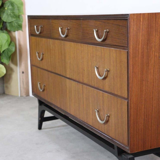 Mid-century British vintage teak chest by Meredew featuring rich wood grain, three drawers with brass handles, and sturdy.