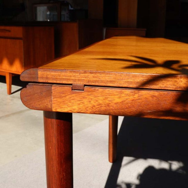 Vintage teak dining table by WhiteANDnewton, mid-century British design with smooth wood grain and rounded legs.