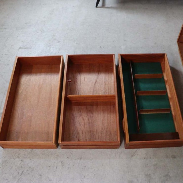 Vintage teak G-Plan mid-century chest with three drawers, showcasing wood grain and green felt-lined compartments.