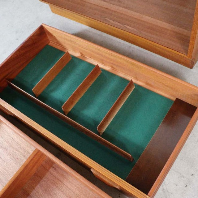 Vintage G-plan teak mid-century chest drawer with green felt-lined compartments and natural wood grain detailing.