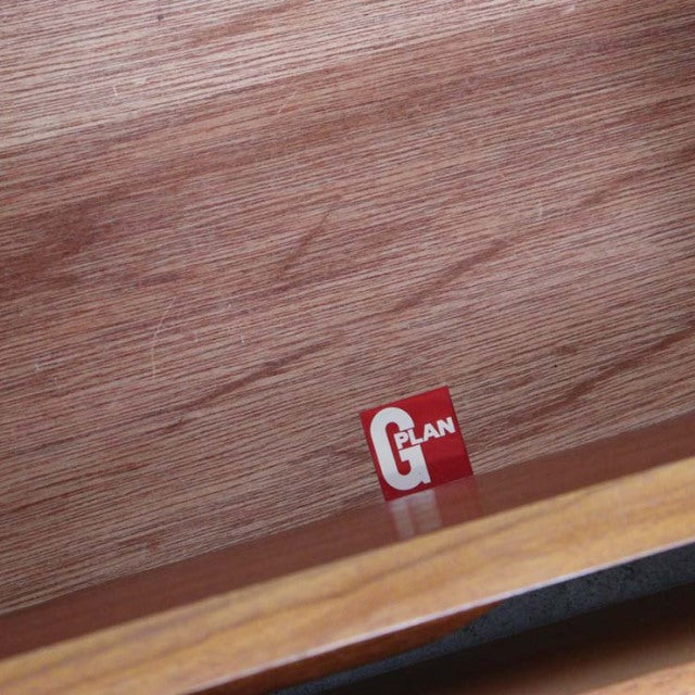Close-up of teak wood grain and red G-plan logo inside vintage British mid-century chest drawer from Denmark.