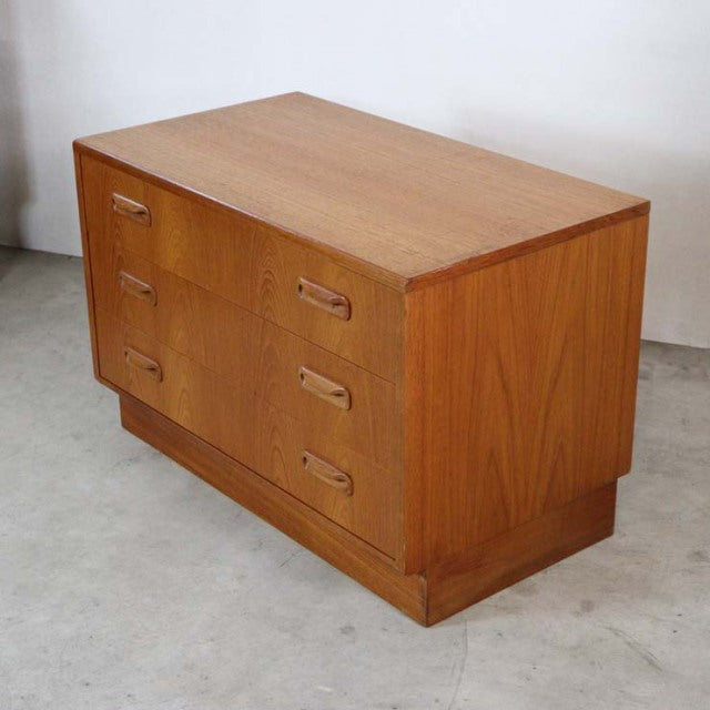 Vintage mid-century British G-Plan teak three-drawer chest with recessed handles and sturdy block base showing rich wood.