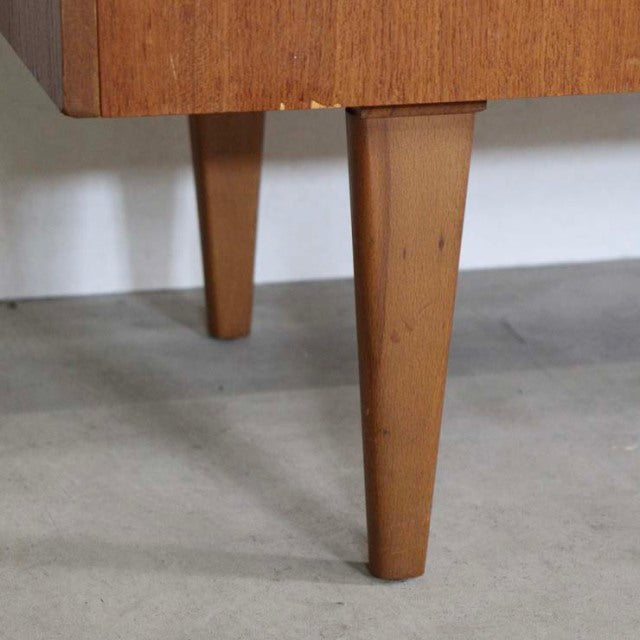 Mid-century vintage British teak sideboard tapered legs with smooth wood grain finish.