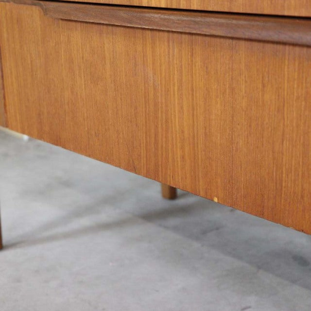 Mid-century vintage teak sideboard leg detail with warm wood grain and slender British Denmark-inspired design.
