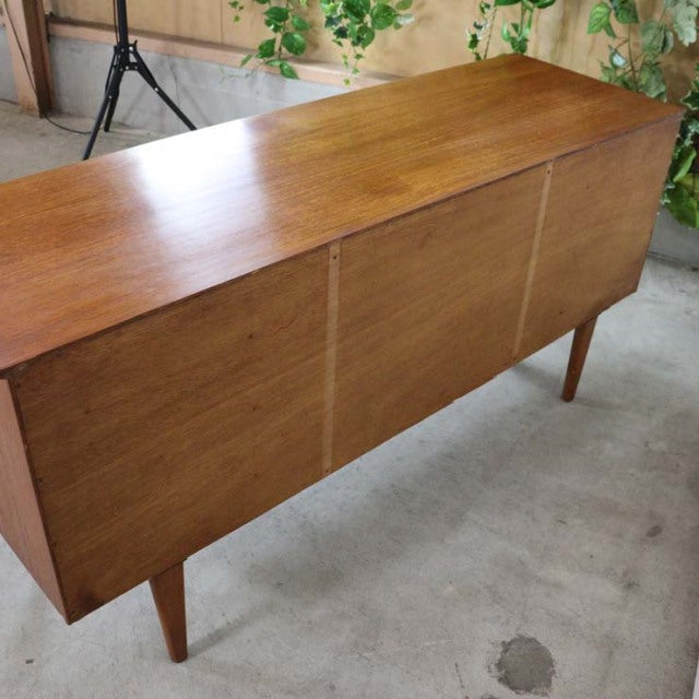 Mid-century British vintage teak sideboard with clean lines, tapered legs, and smooth wood grain finish, crafted in Denmark.